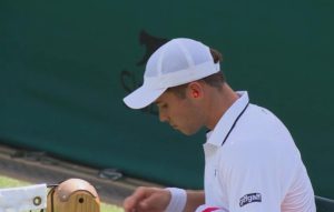 Arthur Fery met des bouchons d&rsquo;oreilles pendant le long discours de Damir Dzumhur à Wimbledon.
